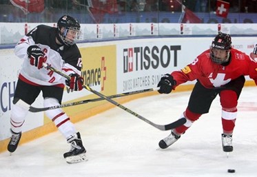 ZUG, SWITZERLAND - APRIL 18: Canada's Jansen Harkins #12 moves the puck up the ice while Switzerland's Calvin Thurkauf #18 defends during preliminary round action at the 2015 IIHF Ice Hockey U18 World Championship. (Photo by Francois Laplante/HHOF-IIHF Images)